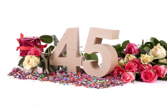 Number of age in a colorful studio setting with fresh roses on a bottom of confetti