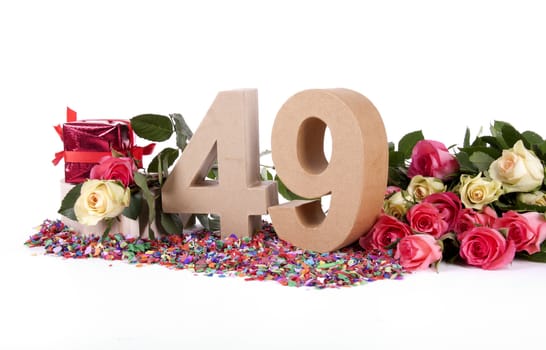 Number of age in a colorful studio setting with fresh roses on a bottom of confetti