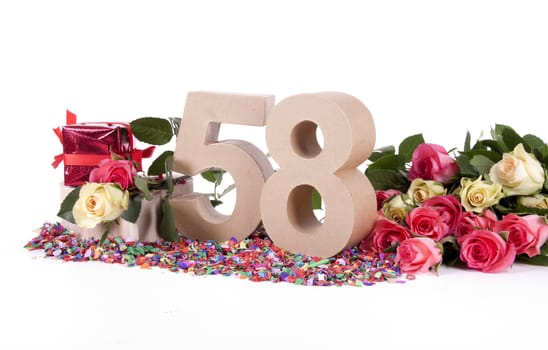 Number of age in a colorful studio setting with fresh roses on a bottom of confetti