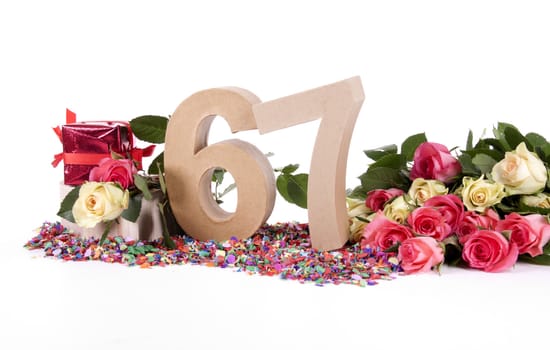 Number of age in a colorful studio setting with fresh roses on a bottom of confetti