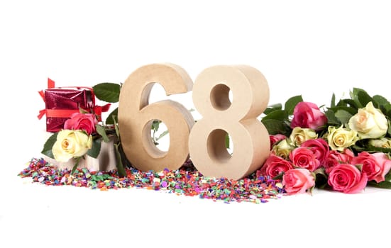 Number of age in a colorful studio setting with fresh roses on a bottom of confetti
