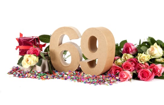 Number of age in a colorful studio setting with fresh roses on a bottom of confetti