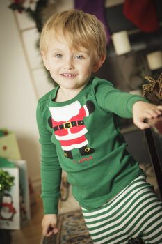 Cute Young Boy Enjoying Christmas Morning Near The Tree.