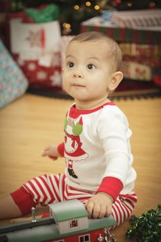 Cute Infant Baby Enjoying Christmas Morning Near The Tree.