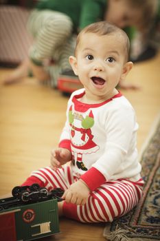 Cute Infant Baby Enjoying Christmas Morning Near The Tree.