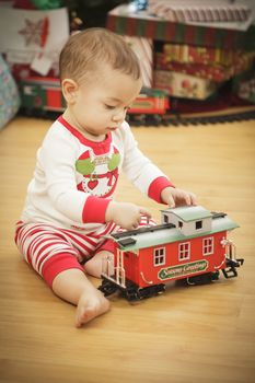 Cute Infant Baby Enjoying Christmas Morning Near The Tree.