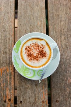 Coffee latte or cappuccino in a cup on wooden background