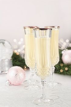 Eggnog in fluted crystal glasses with Christmas decor in the background. Shallow depth of field with selective focus on glass in foreground.