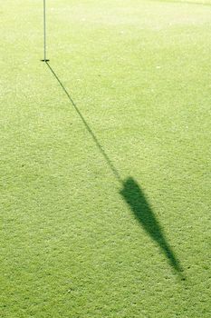 Golf Hole with shadow of flag on green 