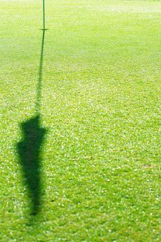 Golf Hole with shadow of flag on green 