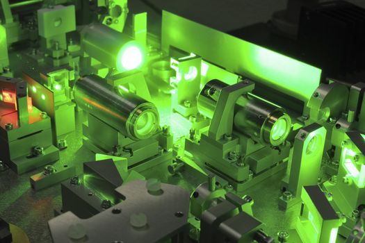 bright green laser light going inside complicate scientific system;
selective focus on central part of image