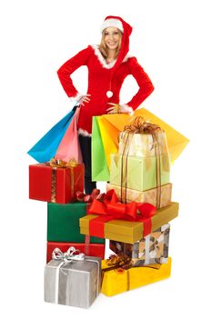 Female with christmas costume standing behind pile of colorful christmas presents, isolated on white