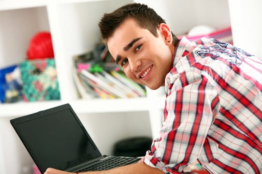 Closeup of handsome man working with laptop at home