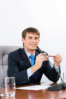 Portrait of a businessman sitting at a table and holding a pen