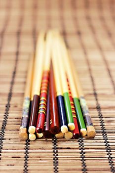 Closeup of various colorful chopsticks on bamboo background