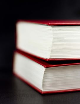 Side view of two red books on a black background