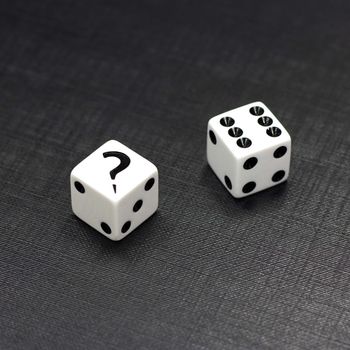 Two white dices on a black background