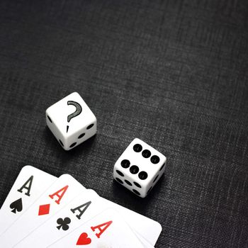 Two white dices and playing cards on a black background