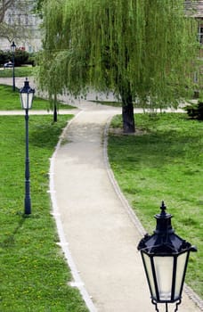Asphalt path in a park with lanterns in Prague, Czech Republic