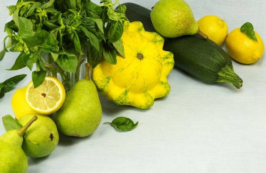 Still life of squashes, basil, pears, lemons on a background on a fabric background