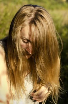 Blond hair young woman in a park