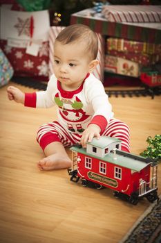 Cute Infant Mixed Race Baby Enjoying Christmas Morning Near The Tree.