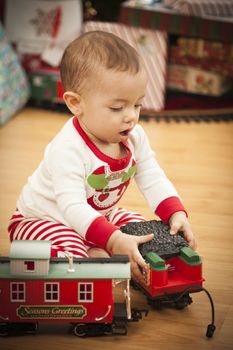 Cute Infant Mixed Race Baby Enjoying Christmas Morning Near The Tree.