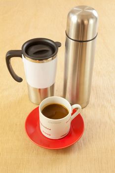 metal cup and water bottle on wood background