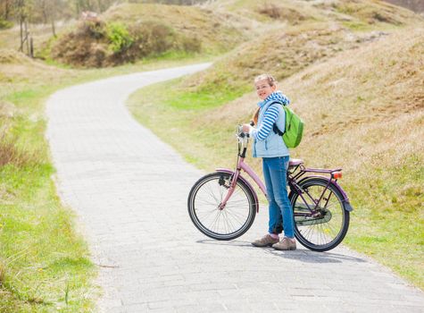 Cute girl with the bike in the park on a spring day