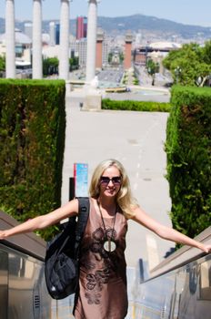 Smiling young woman standing on stairs in Barcelona Spain