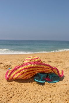 Beach items: pink straw hat, shoes, starfish