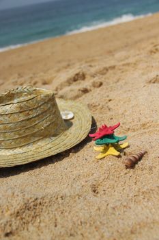 Funny starfishes on the beach and straw hat