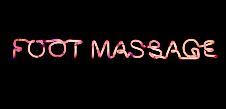 Foot massage pink  neon sign on black background