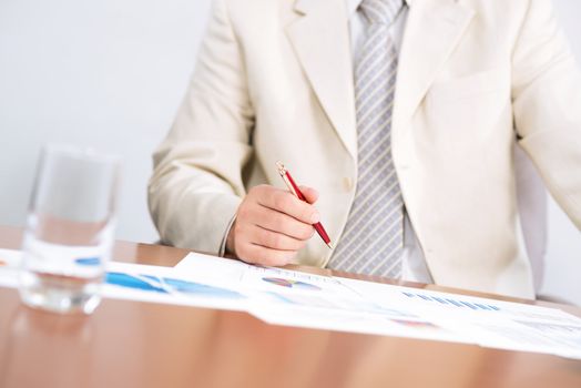 businessman sitting at a table and holding a pen