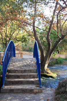 Beautiful autumn park with a stone bridge over the river