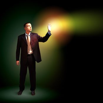 Young successful businessman holding a shining light in his hand as a symbol of success and advancement.