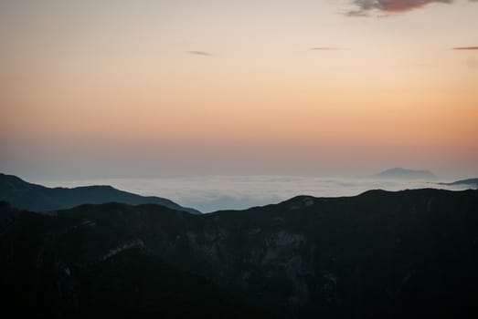 Sunset in Caucasian Mountains in summer with fog