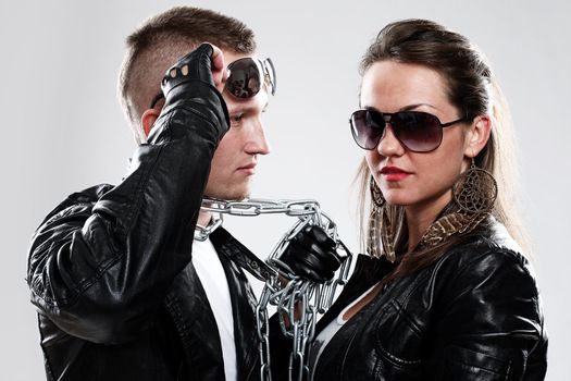 Young brutal couple in leather and sunglasses in studio