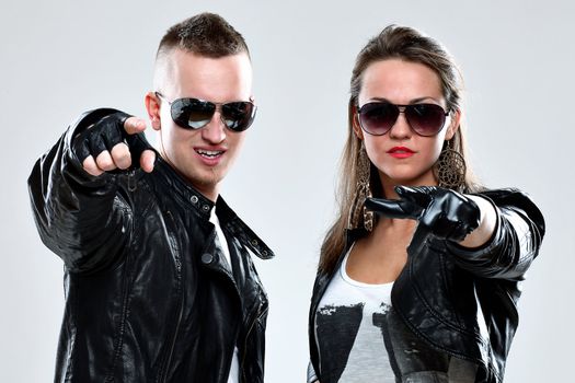 Young brutal couple in leather and sunglasses in studio