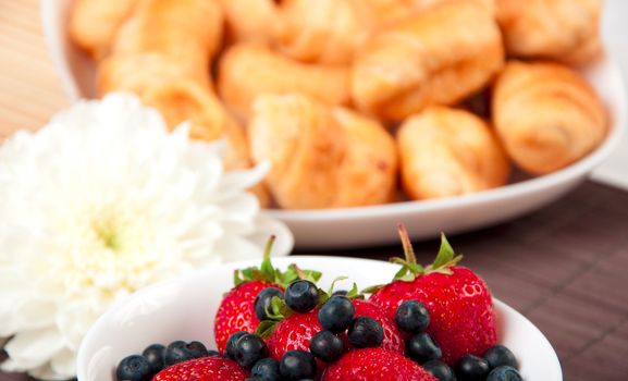 Breakfast with berries, milk and croissant, early breakfast