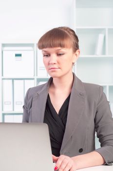 portrait of a beautiful young woman who works at a laptop in the office