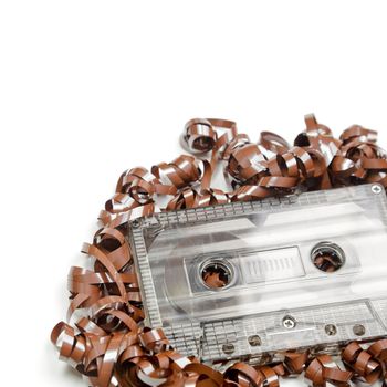 Vintage transparent Compact Cassette with pulled out tape on white background