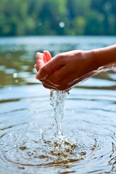 Water pouring out of a young woman's hands