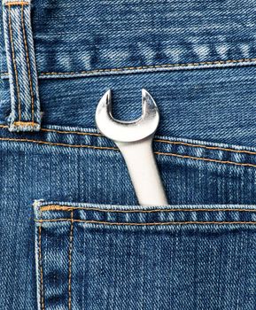 Blue jeans pocket with chrome lug wrench