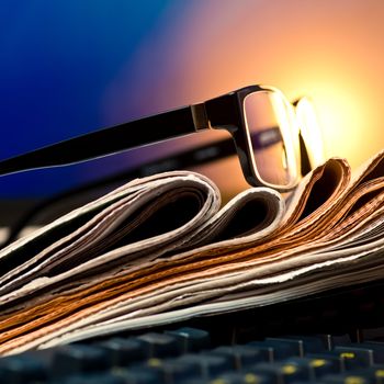 Glasses on stack of newspapers, very shallow focus