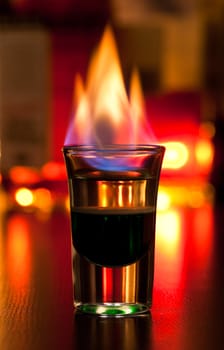 Burning cocktail in shot glass on a table, shallow focus