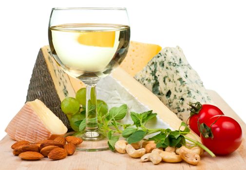 Glass of white wine with various types of cheese and garnishes