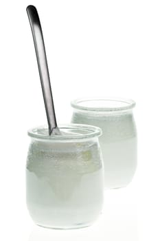 Old-fashioned yogurt jars with spoon on white background