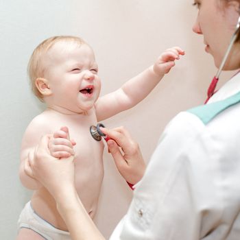 Children's doctor exams infant with stethoscope