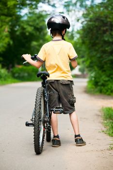 Young boy standing with bicycle, shallow dof